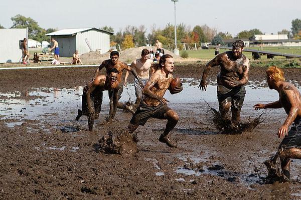 学生们在一年一度的运维泥浆足球比赛中互相竞争. 